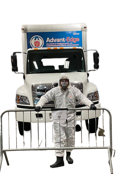 Image of ASMAI employee wearing a hazmat suit posing in front of the trucks with our logo on it