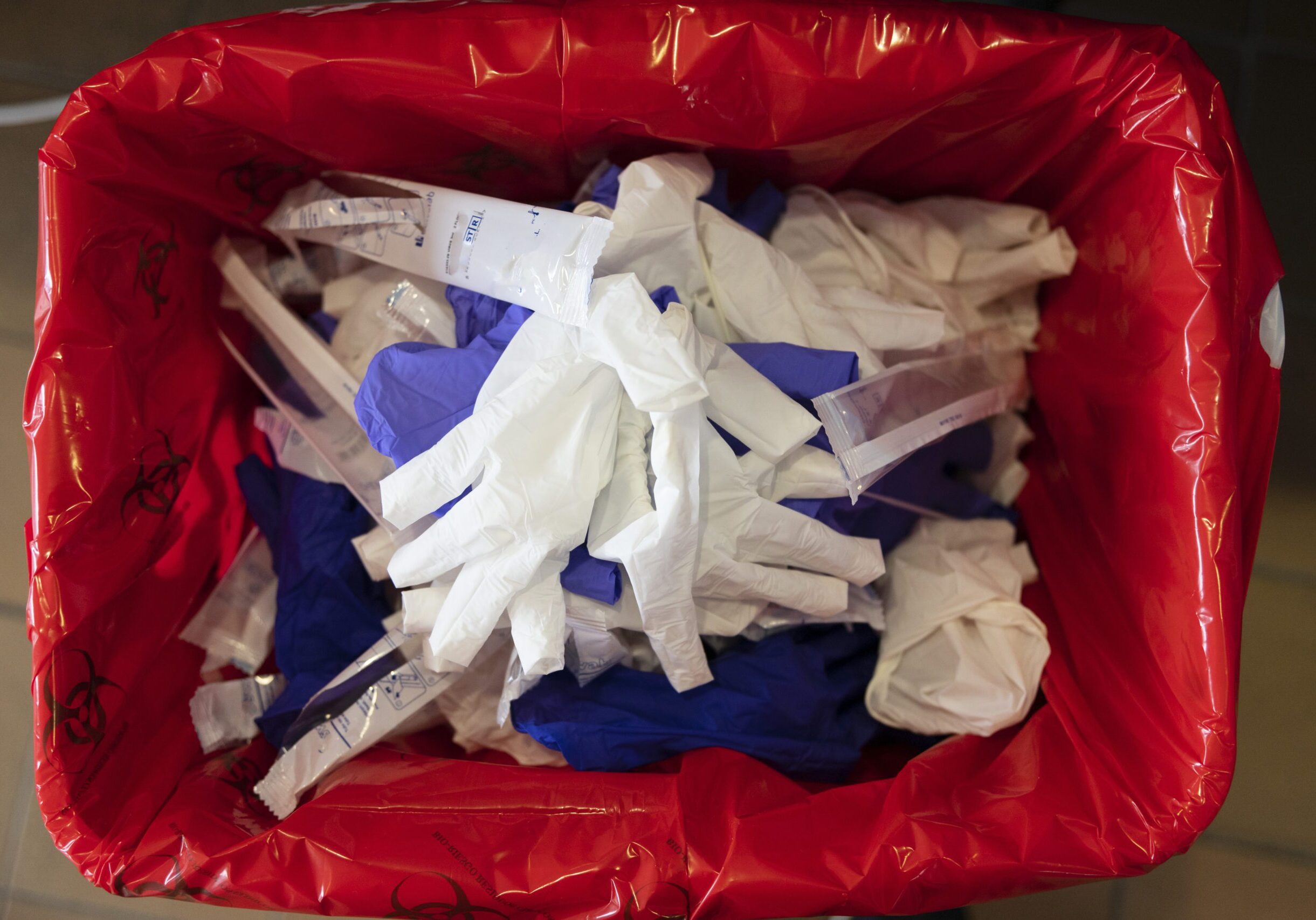 Medical waste disposal like gloves from a healthcare facility in a red bag.