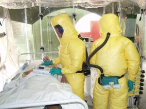 Image of 2 people wearing hazmat suits while handling a patient with ebola