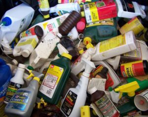 Bottles of chemicals awaiting hazardous waste disposal, illustrating proper handling of dangerous materials.
