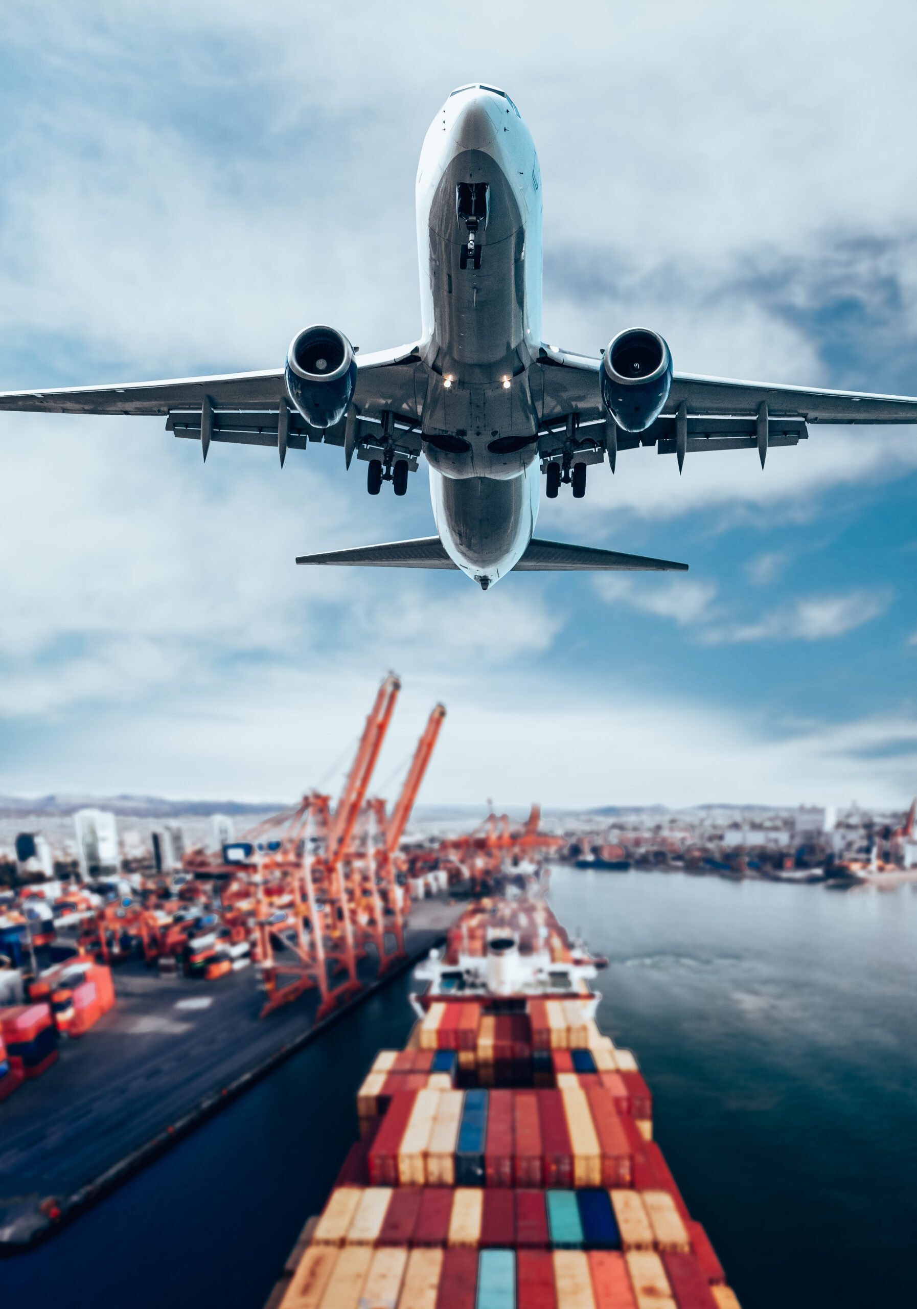 Image of a plane flying over a storage container ship