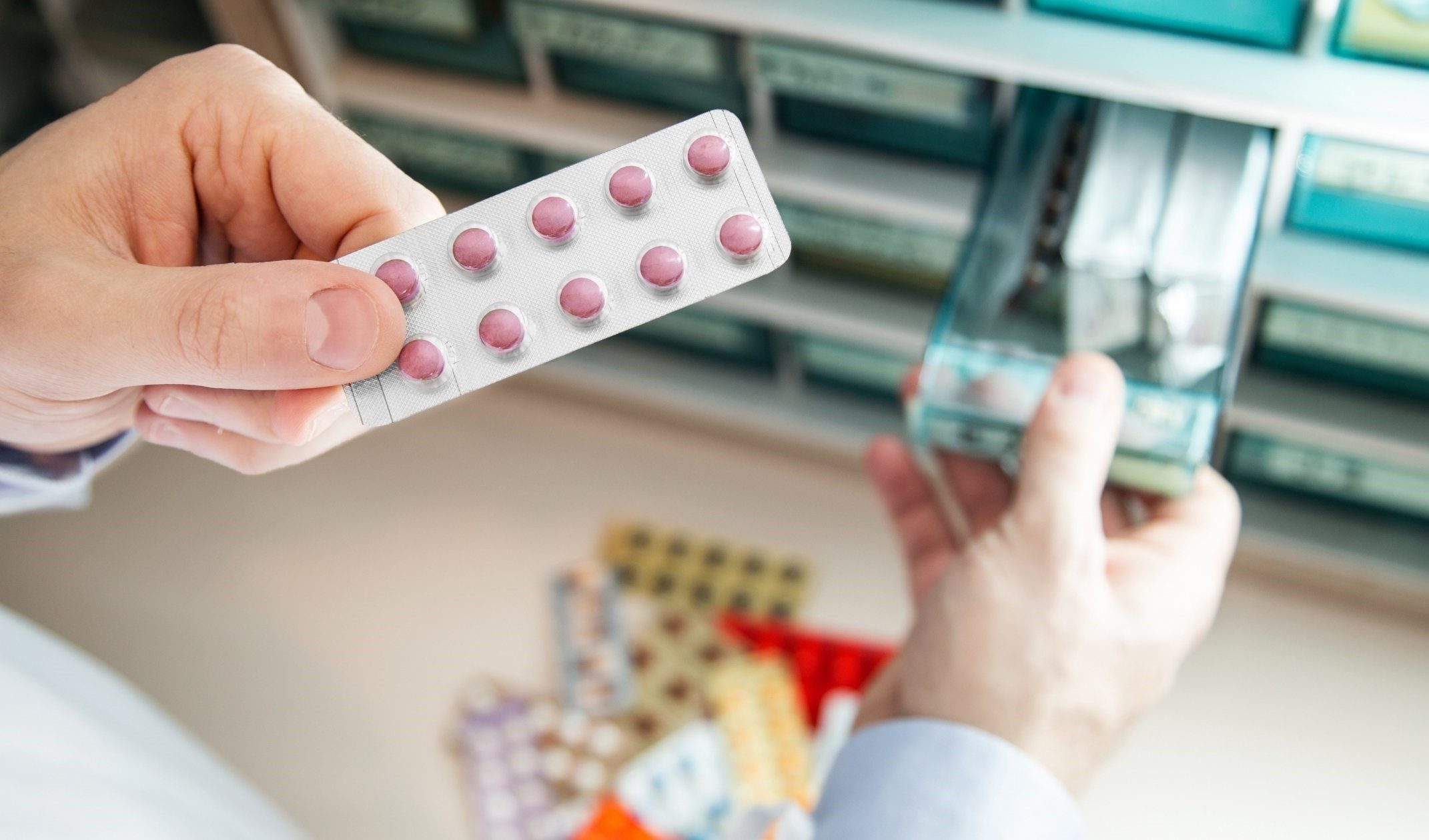 Pharmacist handling blister packs of pills, highlighting safe practices for disposing pharmaceutical waste.